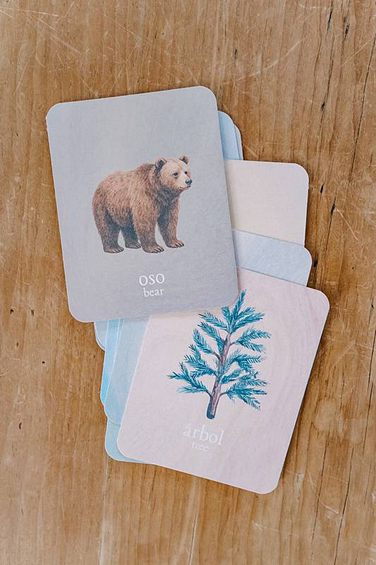 Image of cards stacked on a table with an illustration of a bear and an illustration of a tree.