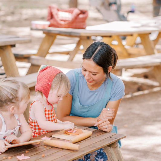 Woman and two children at a picnic table outdoors