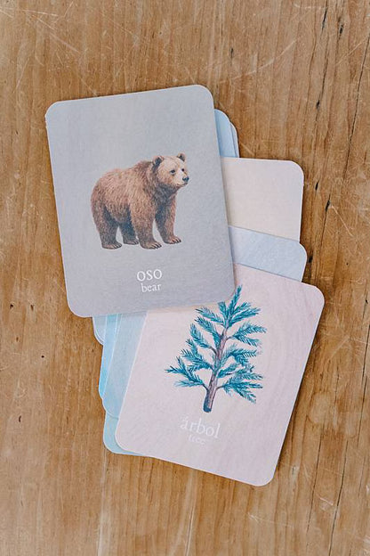 Image of cards stacked on a table with an illustration of a bear and an illustration of a tree.