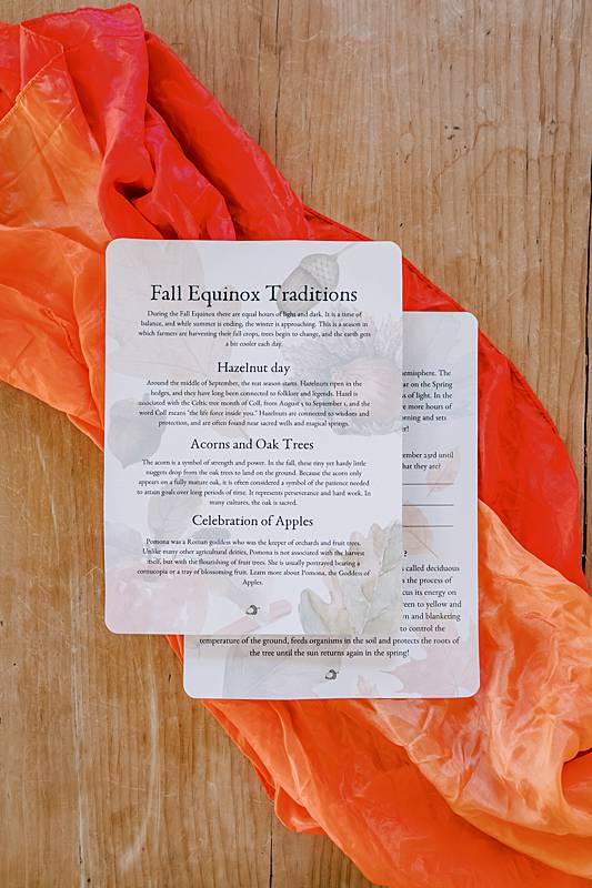 cards laying on a play silk on a wooden table