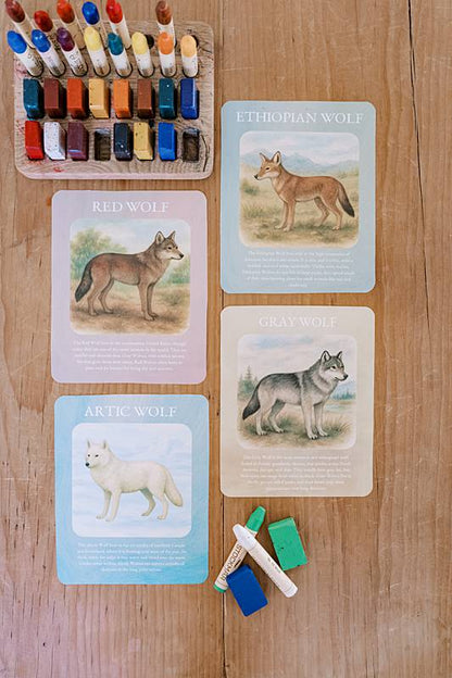 Four cards laying next to crayons