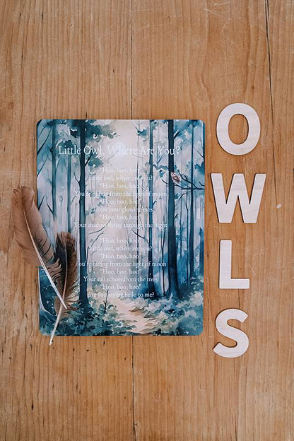 A card with wooden letters and feathers on a table