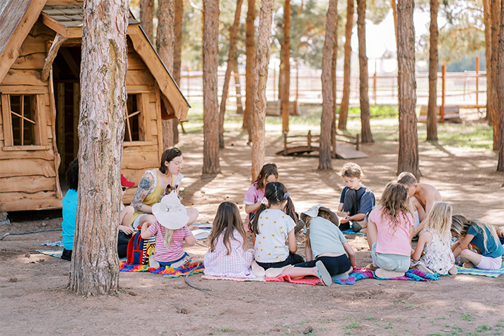 Children's circle with woman reading to them outloud