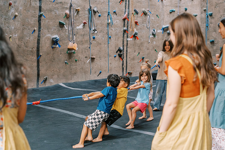 Children playing tug-of-war in a rock gym. 