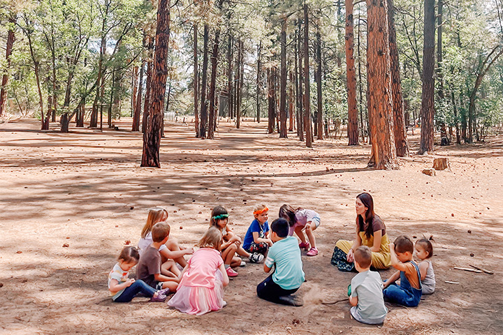 Children sitting in a circle in the woods